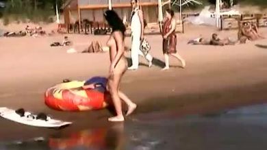 Une danseuse nue et sexy se fait bronzer sur la plage.