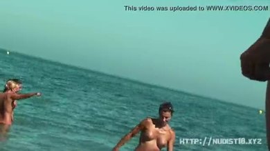 Une étonnante femme complètement nue se tient sur une plage sans rien porter.