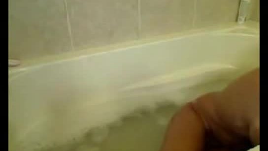 Blonde maigre et bronzée nue dans une baignoire
